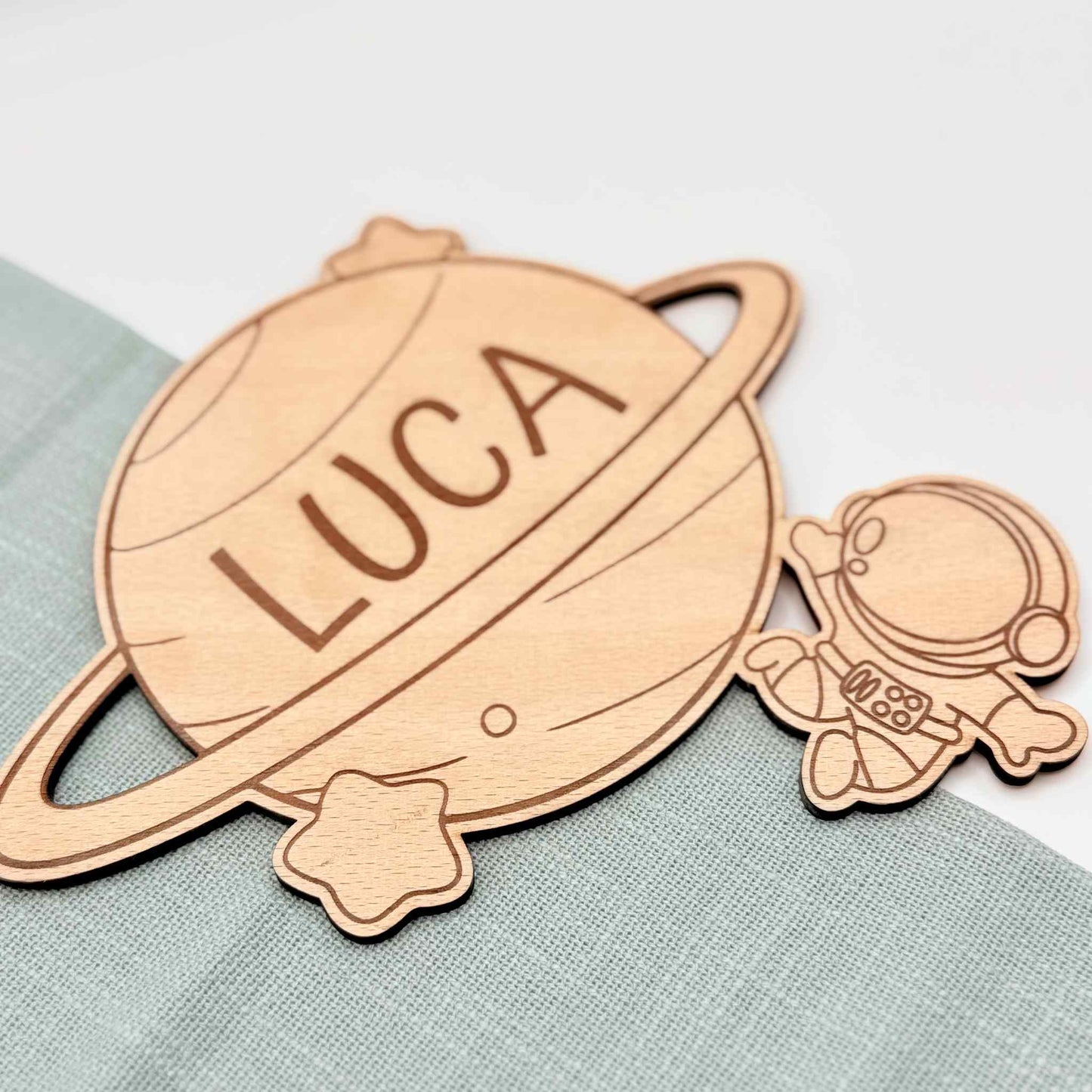 Ein Türschild mit Namen aus Holz und Astronauten Motiv