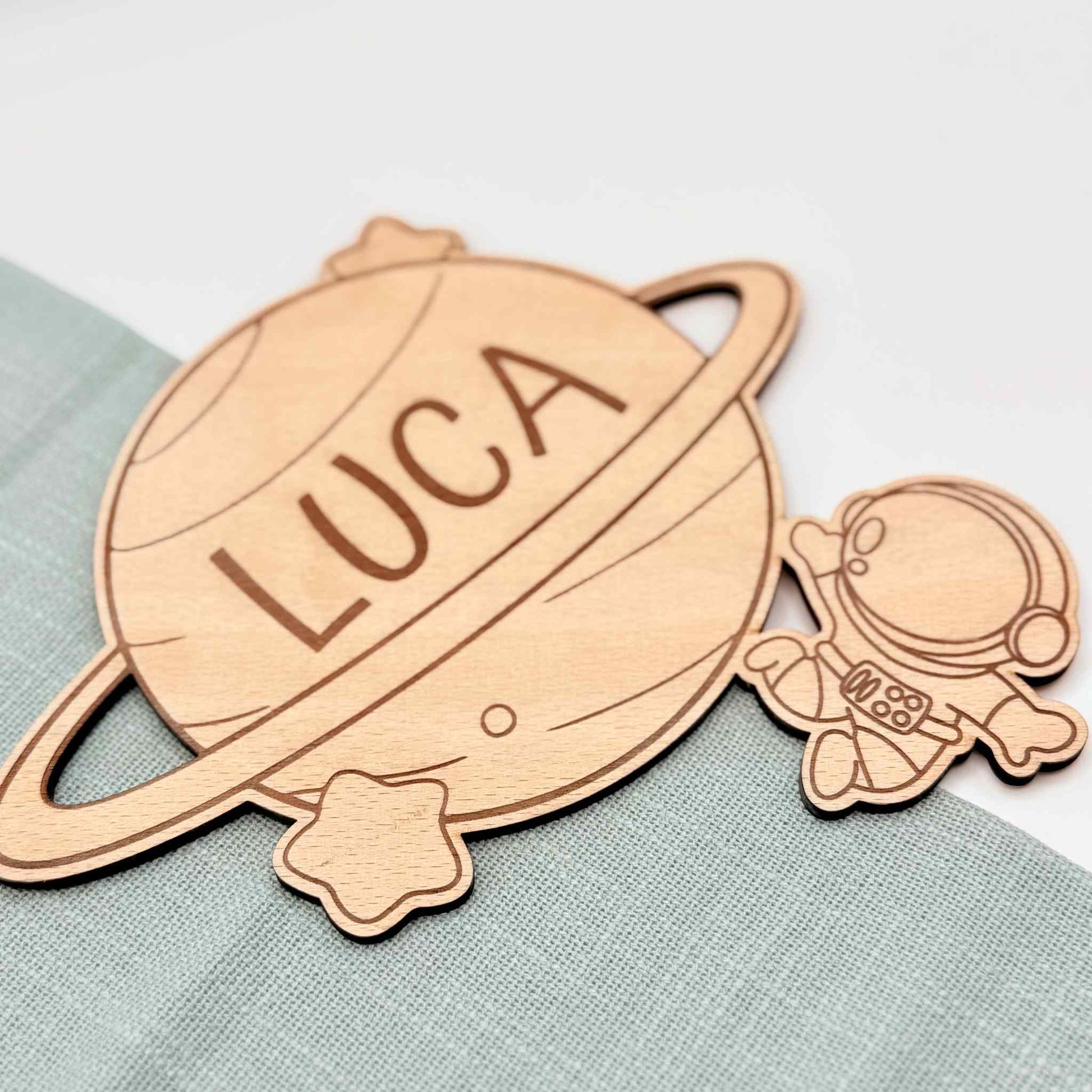 Ein Türschild mit Namen aus Holz und Astronauten Motiv