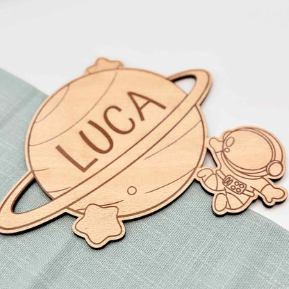 Ein Türschild mit Namen aus Holz und Astronauten Motiv